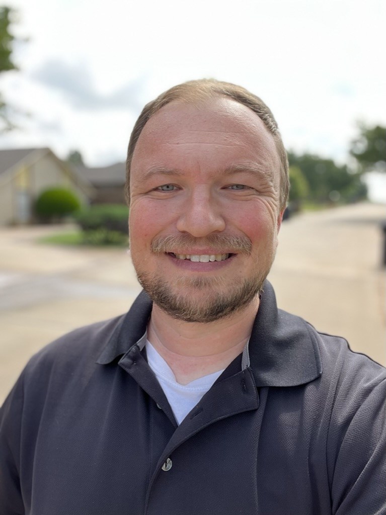 Dustin Walker, LPC, smiling outdoors