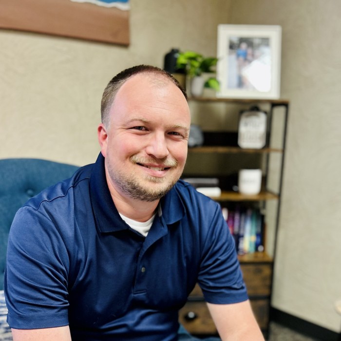 Dustin Walker, LPC, smiling in his Edmond, OK office